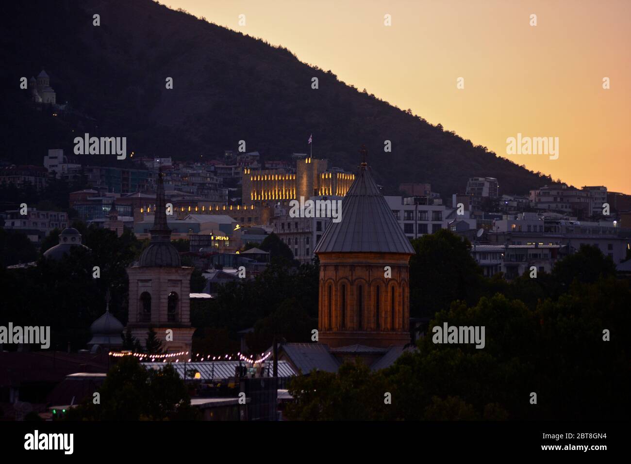 Tbilisi: Construcción del Gobierno de Georgia y el Monte Mtatsminda al crepúsculo. República de Georgia Foto de stock