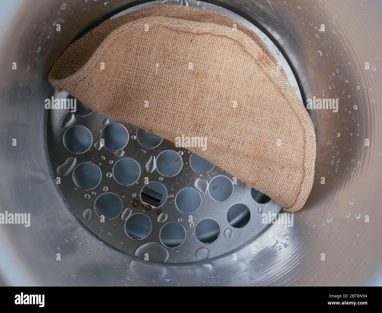 Dentro de una olla de vapor de suelo con rejilla y tela de yute. Foto de stock