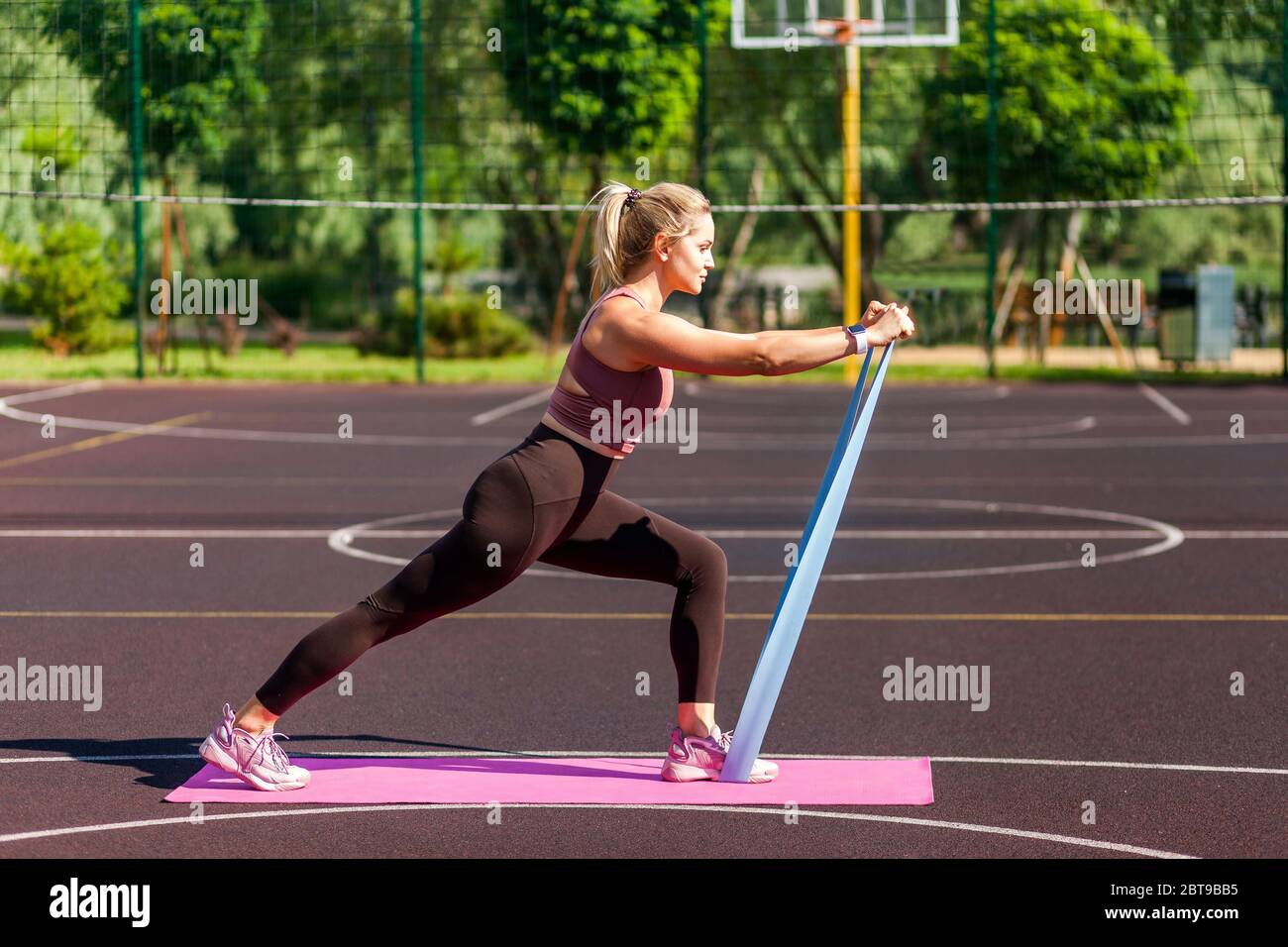 Mujer atlética entrenando con bandas de goma de fitness en el campo de  entrenamiento entrenamiento de resistencia