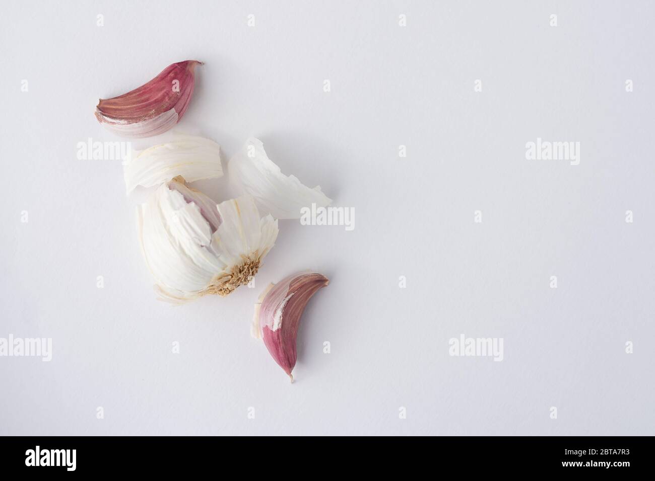 Una bombilla de ajo con clavos sacados sobre un fondo blanco visto desde arriba Foto de stock