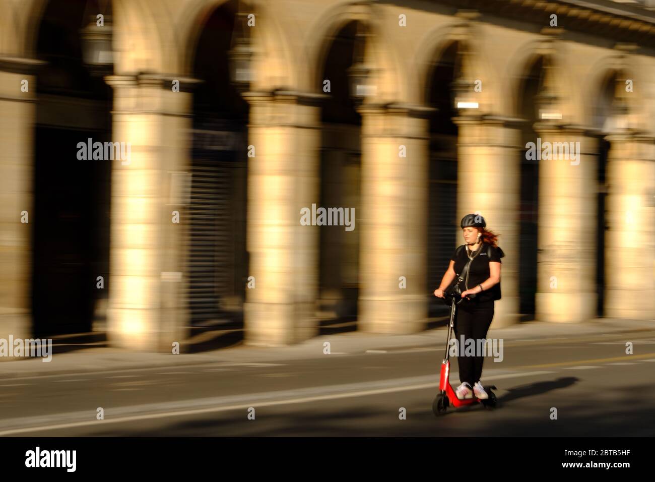 París, Francia. 24 de mayo de 2020. Una mujer monta un scooter en la Rue de Rivoli, mientras los parisinos se vuelven lentamente a las calles mientras París emerge del encierro del coronavirus. Crédito: Pierre Stevenin/ZUMA Wire/Alamy Live News Foto de stock