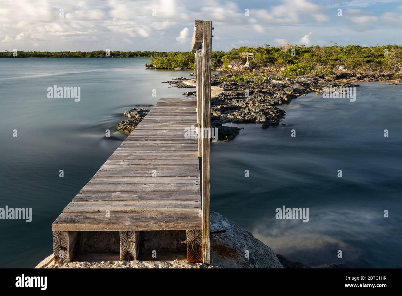Una larga exposición de agua corriendo bajo el puente peatonal de madera a Jack's Island, Pine Cay, West Indies, julio de 2019 Foto de stock