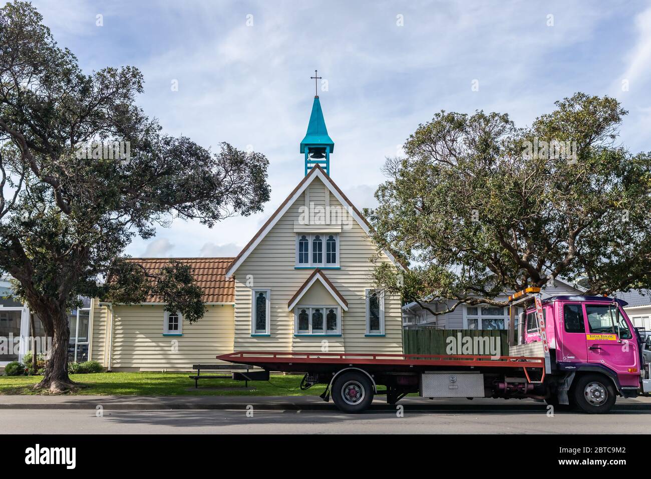 Una capilla/iglesia blanca con campanario azul y un camión rosa aparcado fuera, Miramar, Wellington, Nueva Zelanda, Foto de stock