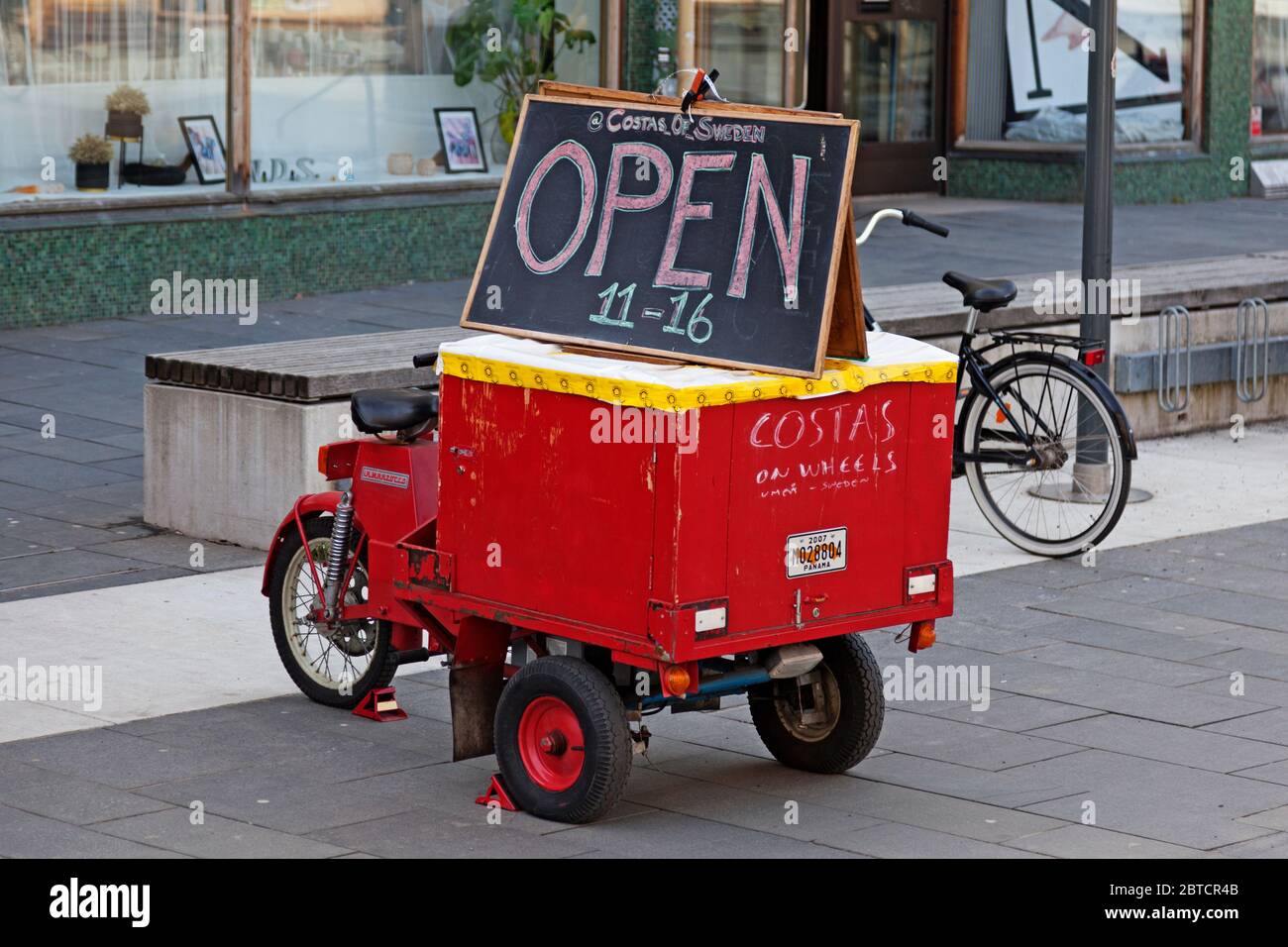 Umea, Norrland Suecia - 6 de abril de 2020: Ciclomotor rojo antiguo con cartel para restaurante Foto de stock