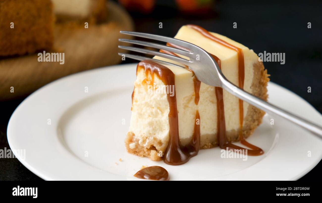 Comer deliciosa tarta de queso con salsa de caramelo, Vista de primer plano Foto de stock
