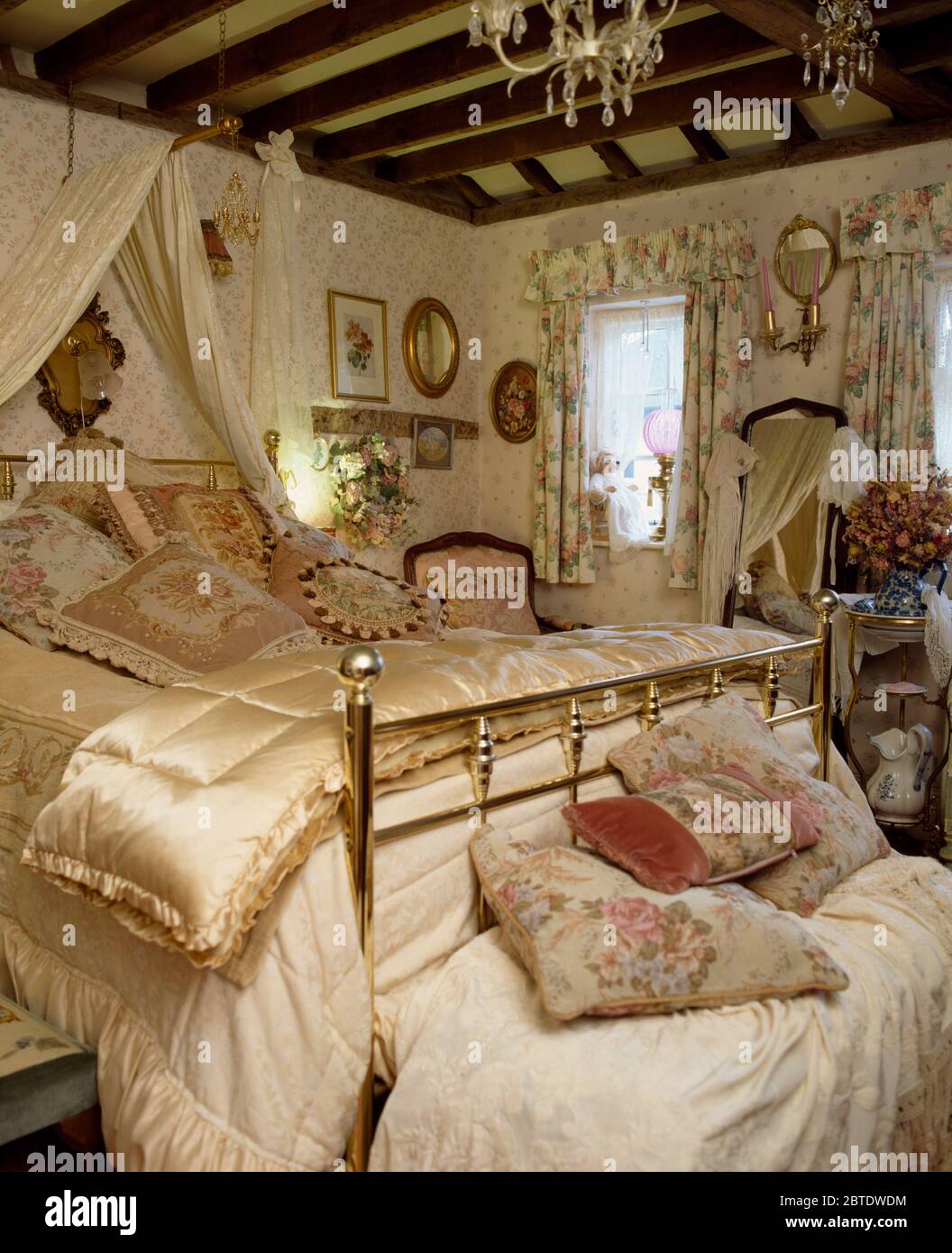 Edredón de satén en cama de bronce en un pequeño dormitorio estilo  victoriano Fotografía de stock - Alamy