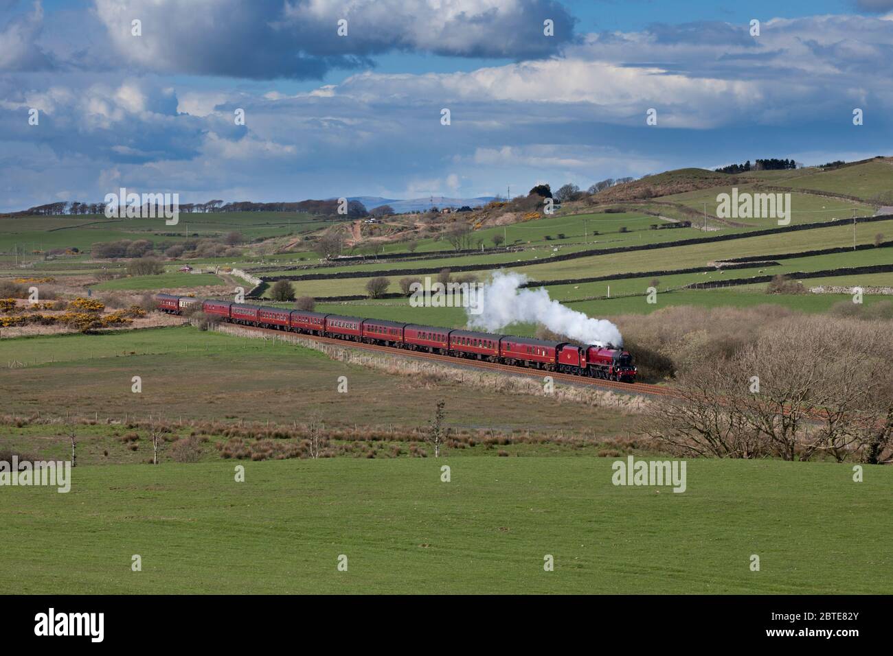 Locomotora de vapor 45699 Galatea transportando un tren charter de línea principal por el campo en la línea escénica de ferrocarril de la costa de Cumbria Foto de stock
