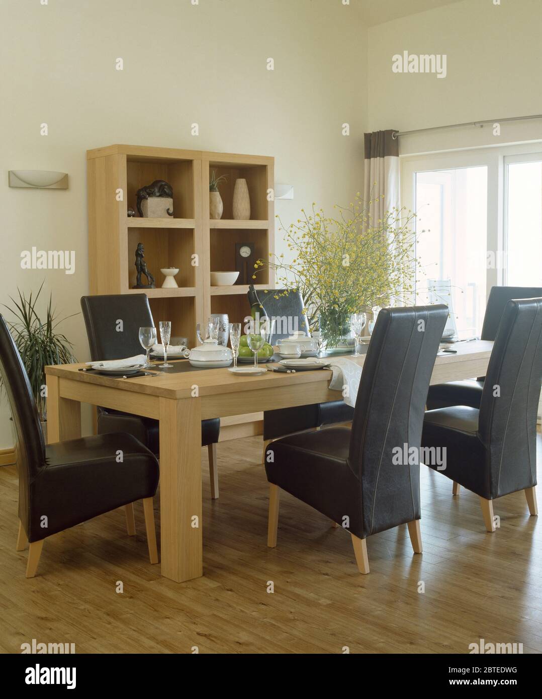 Sillas de cuero negro tapizadas en la mesa en el moderno comedor Fotografía  de stock - Alamy