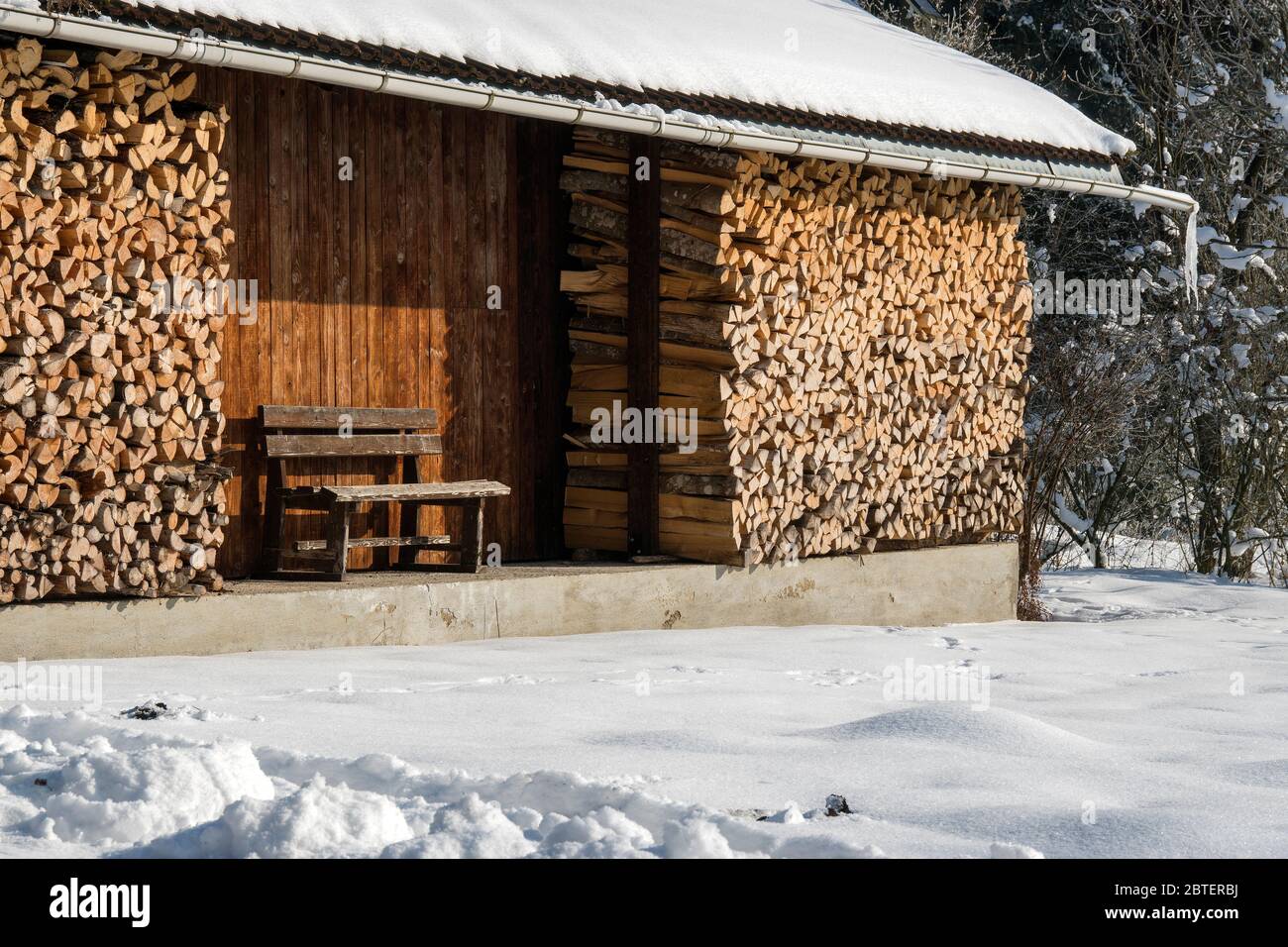 Stadel im Winter mit aufgeschichtetem Brennholz Foto de stock