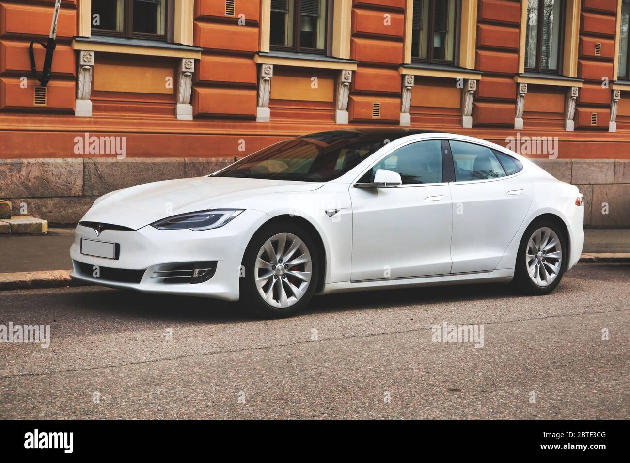 Hermoso coche blanco Tesla Model S completamente eléctrico estacionado en la calle de la ciudad fuera del edificio histórico. Helsinki, Finlandia. 24 de mayo de 2020. Foto de stock