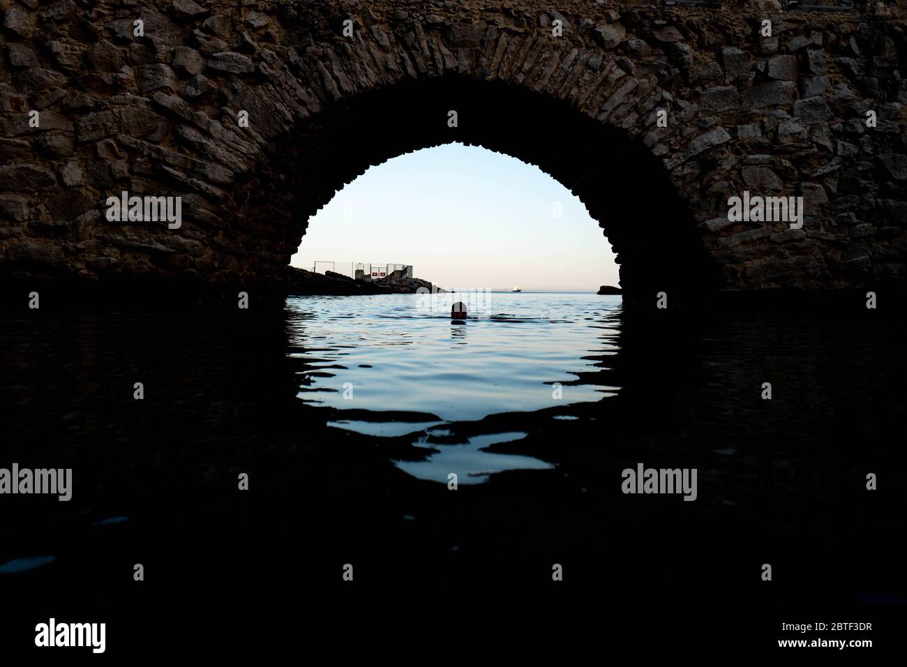 Europa, Portugal, Caiscas. Un hombre nadaba en medio del puente que delimita el Palácio dos Condes de Castro Guimarães en Caiscas. Foto de stock