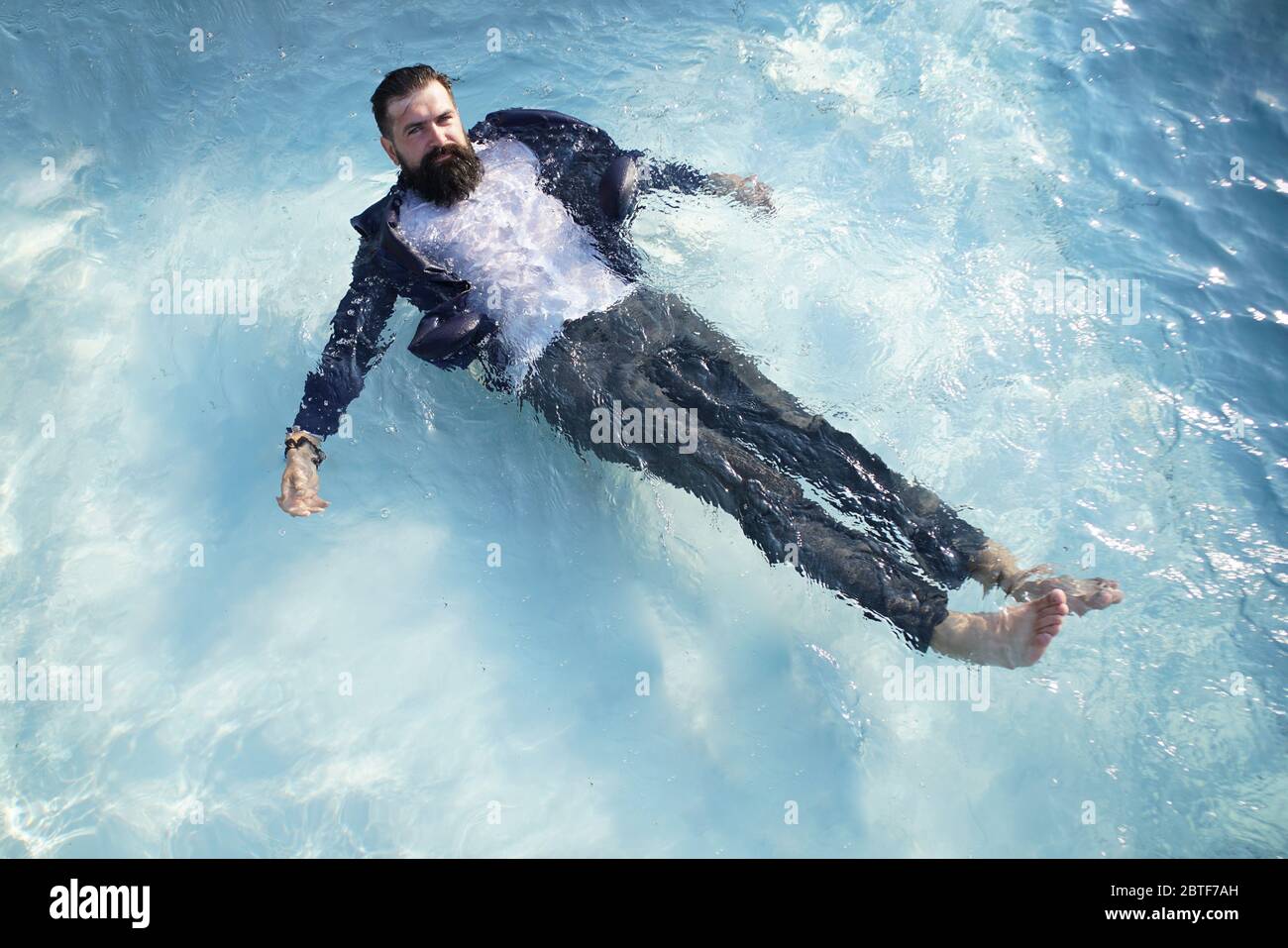 Un hombre de negocios con barba gracioso en traje en la piscina. Hombre  feliz con vestido en la piscina Fotografía de stock - Alamy