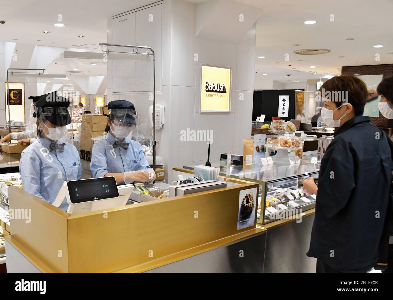 Tokio, Japón. 25 de mayo de 2020. Los empleados que usan protectores faciales y máscaras faciales trabajan en el almacén del departamento de Matsuya Ginza, que reabrió parcialmente en Tokio, Japón, el lunes 25 de mayo de 2020. El primer ministro Shinzo Abe le dio un callado a los ciudadanos, "necesitamos cambiar a un nuevo estilo de vida para volver a las actividades socioeconómicas normales durante la lucha a largo plazo contra el nuevo coronavirus" en una conferencia de prensa. Foto de Keizo Mori/UPI crédito: UPI/Alamy Live News Foto de stock