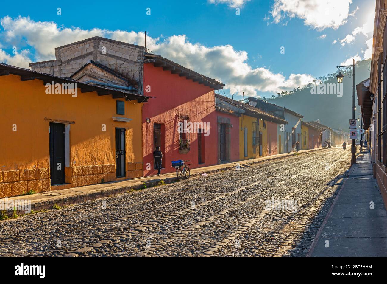 Vida de la ciudad al amanecer en las coloridas calles de estilo colonial de Antigua, Guatemala. Foto de stock