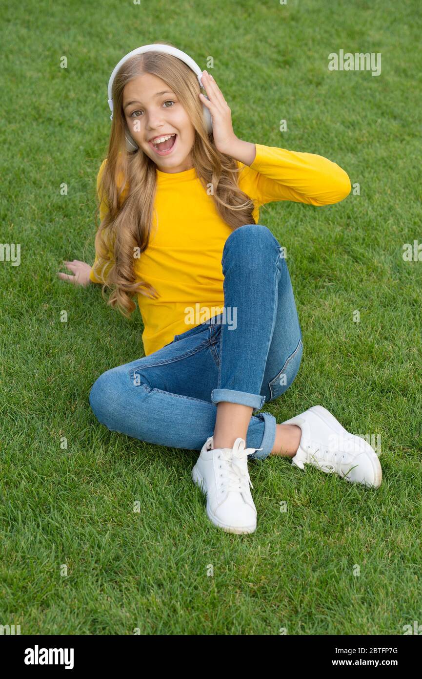 Escuchar Sonidos De La Naturaleza Para Relajarse lista de reproducción de primavera. niña feliz escuchar su canción  favorita. moda de belleza infantil. niña escuchar música. sonidos de la  naturaleza. relajarse en el césped verde. tiempo de ocio en primavera.