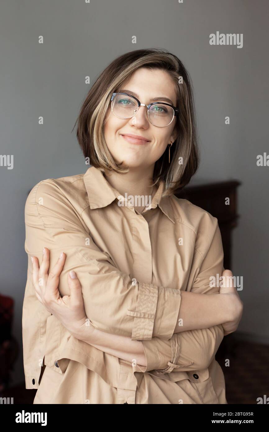 Retrato de una mujer intelectual creíble y elegante. Una sonrisa agradable, gafas. El concepto de médico, psicólogo, psiquiatra, blogger, diseñador. Foto de stock