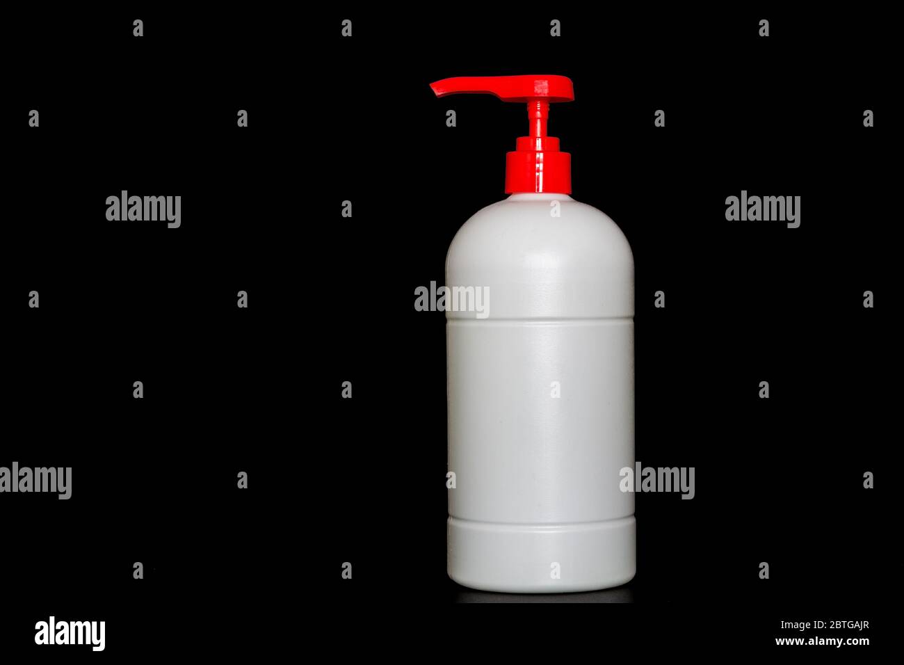 Botella de plástico blanco de la bomba de empuje aislada sobre fondo negro, espacio de copia publicidad de texto área Foto de stock