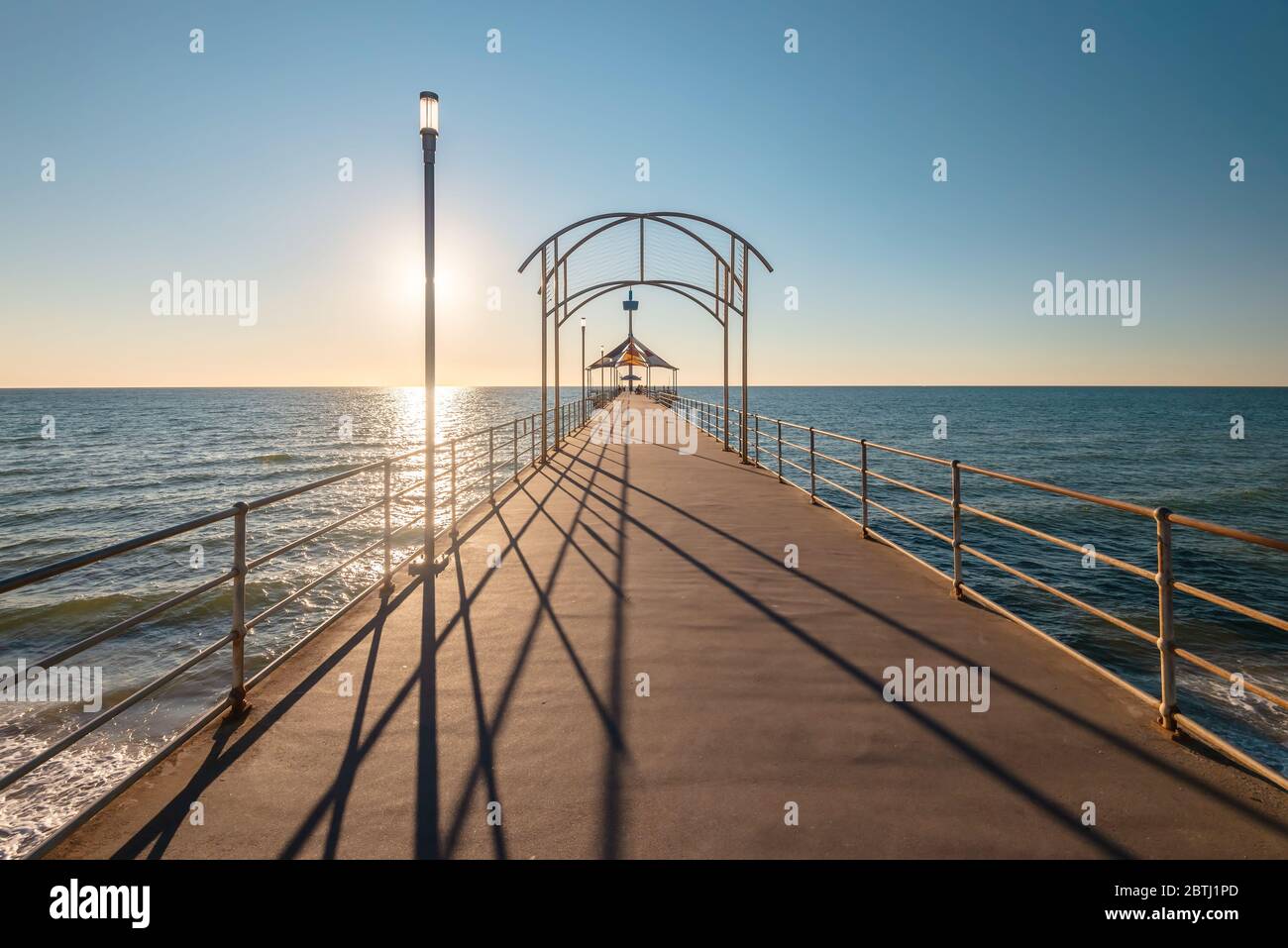 El emblemático Brighton Jetty al atardecer con cielo azul, Australia Meridional Foto de stock