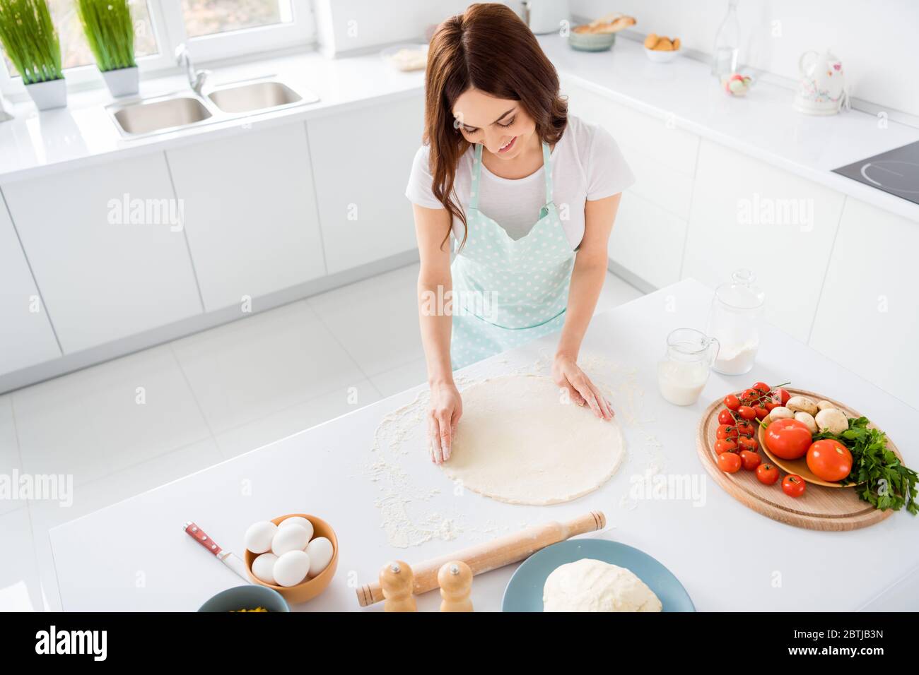 Foto de hermosa y alegre ama de casa disfrutar de la manía preparar la  receta familiar cena formar hacer masa para la pizza moderna cocina  interior ropa informal Fotografía de stock -