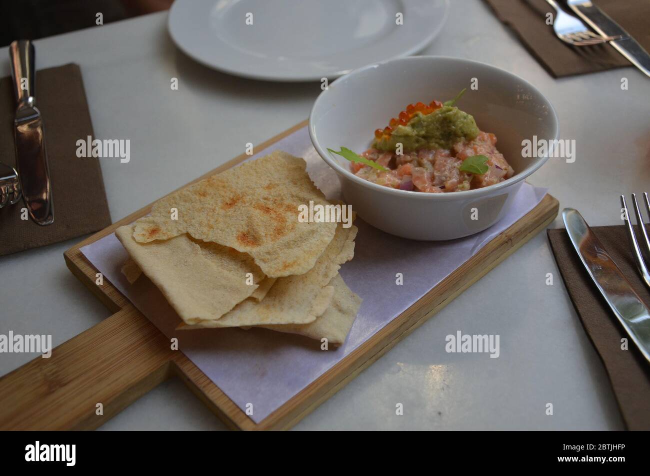 Tartar de salmón con huevas de salmón y aguacate con cracker en el restaurante de tapas español, Barcelona. Foto de stock