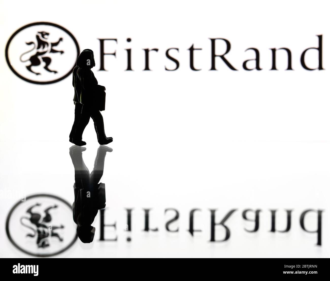 Siluetas delante del logo del grupo FirstRand. (sólo para uso editorial) Foto de stock