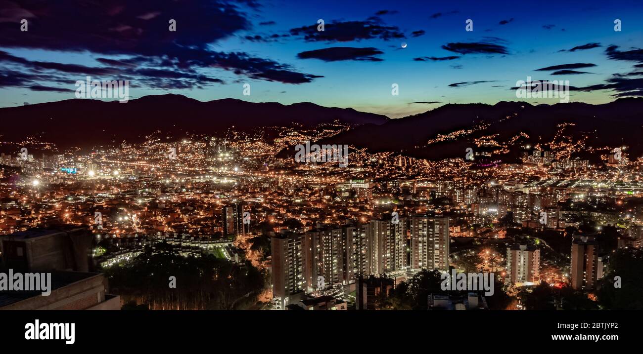 Una vista aérea nocturna de la ciudad de Medellín justo después de la puesta de sol todas las luces del edificio están encendidas Foto de stock