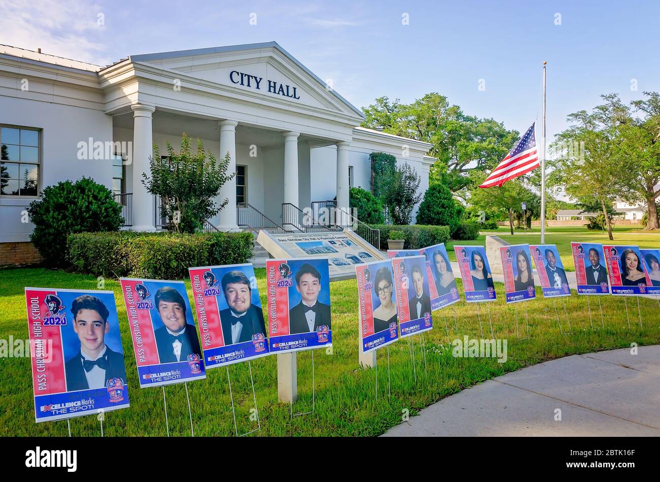 Retratos de Pass los ancianos de la escuela secundaria cristiana están fuera del Ayuntamiento mientras una bandera vuela a media asta en honor de las víctimas de la pandemia de COVID-19. Foto de stock