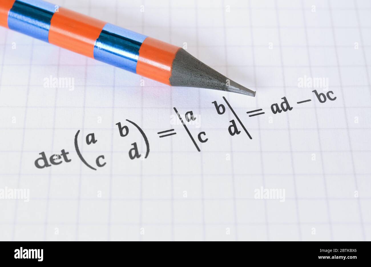 Lápiz y cálculo del determinante de una matriz sobre fondo brillante Foto de stock