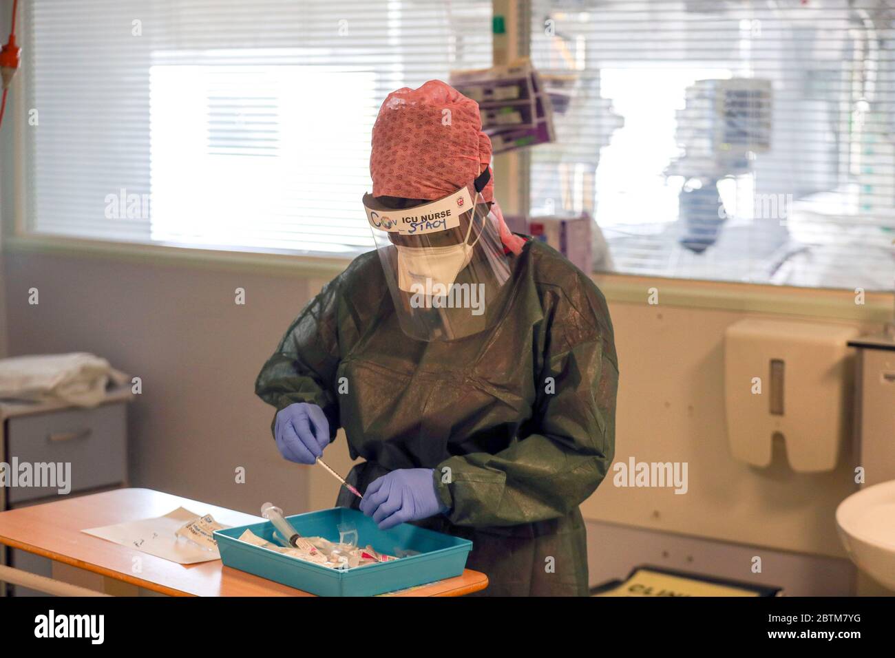 Una enfermera trata a un paciente que sufre de coronavirus en una sala de cuidados intensivos del Hospital Frimley Park en Surrey. Fecha del cuadro: 22/5/2020. Foto de stock