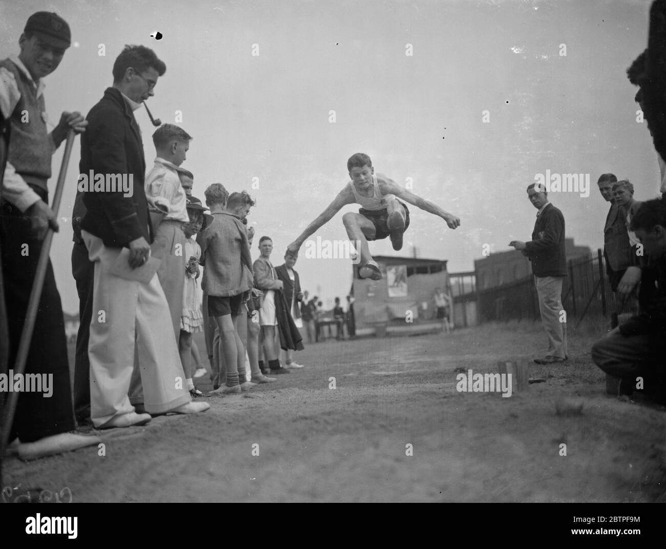 Dartford técnica de deportes universitarios. Atrapado en el aire durante el salto largo. 1938 Foto de stock