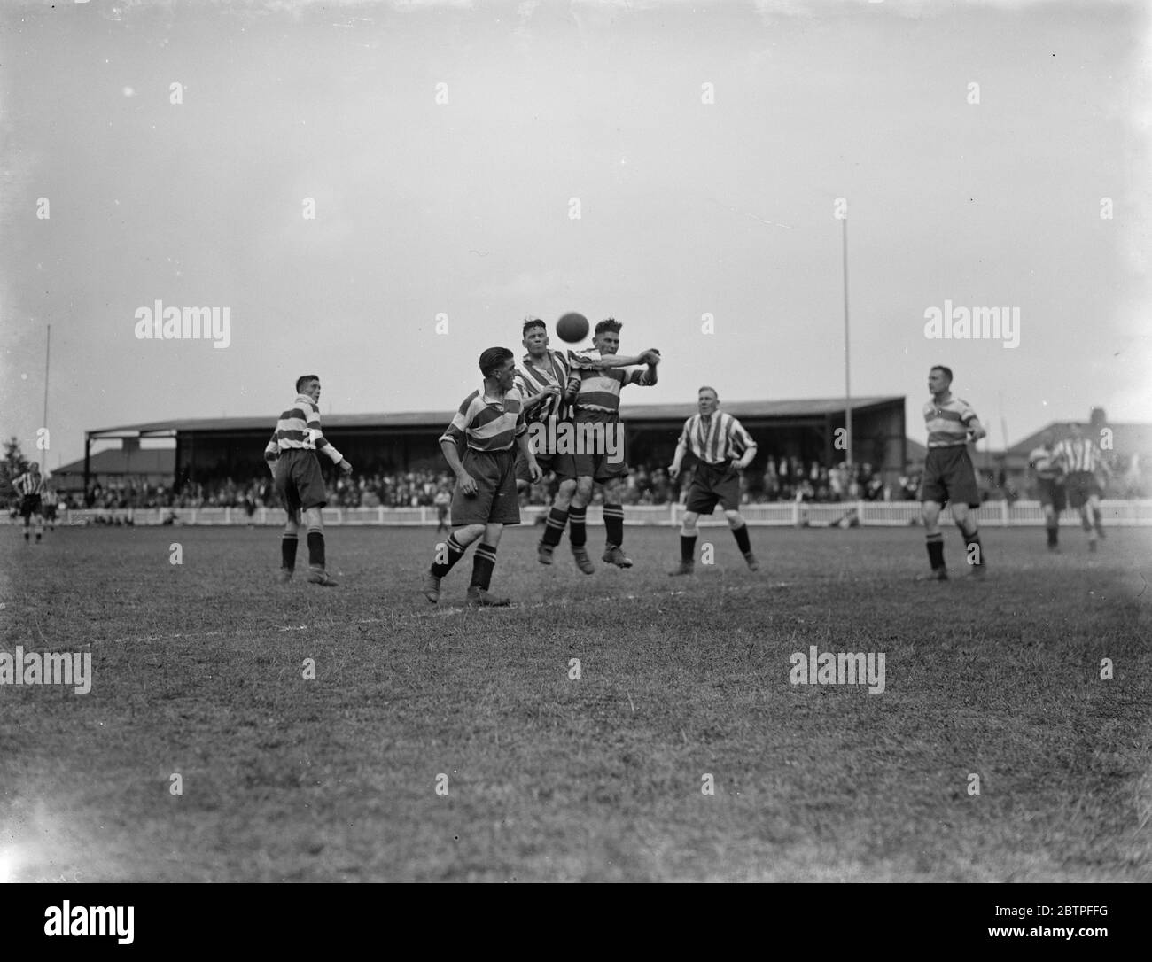 Futbolistas en Dartford. Los jugadores compiten por la pelota en el aire. 1936 Foto de stock