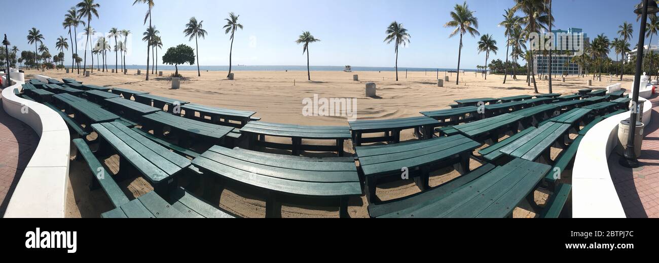 Panorama muestra mesas de picnic apiladas en la playa cerrada de Florida Beach Foto de stock