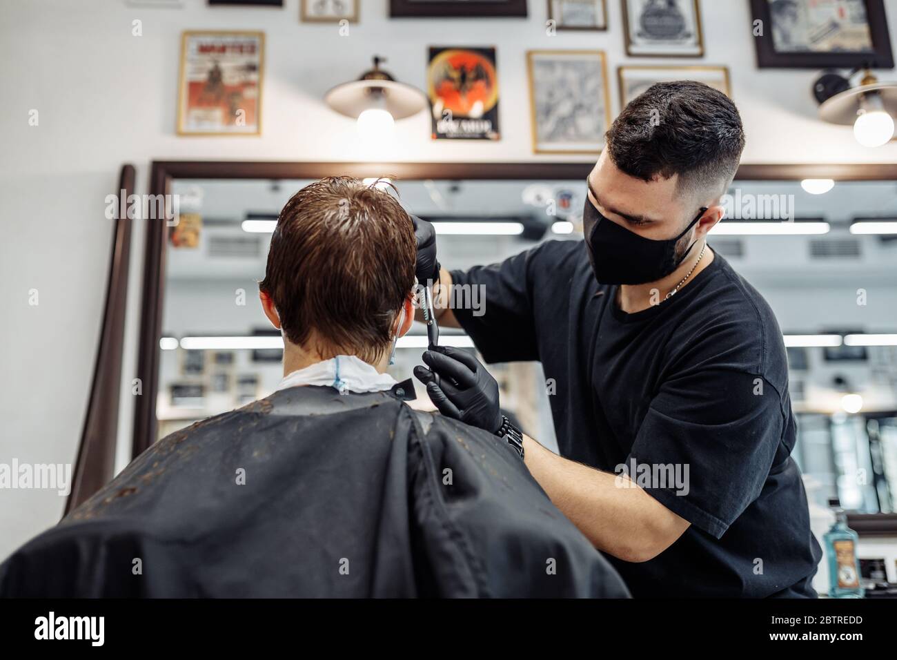 Adelgazamiento y peinado del cabello. Peluquería hace un corte de pelo al cliente. Foto de stock