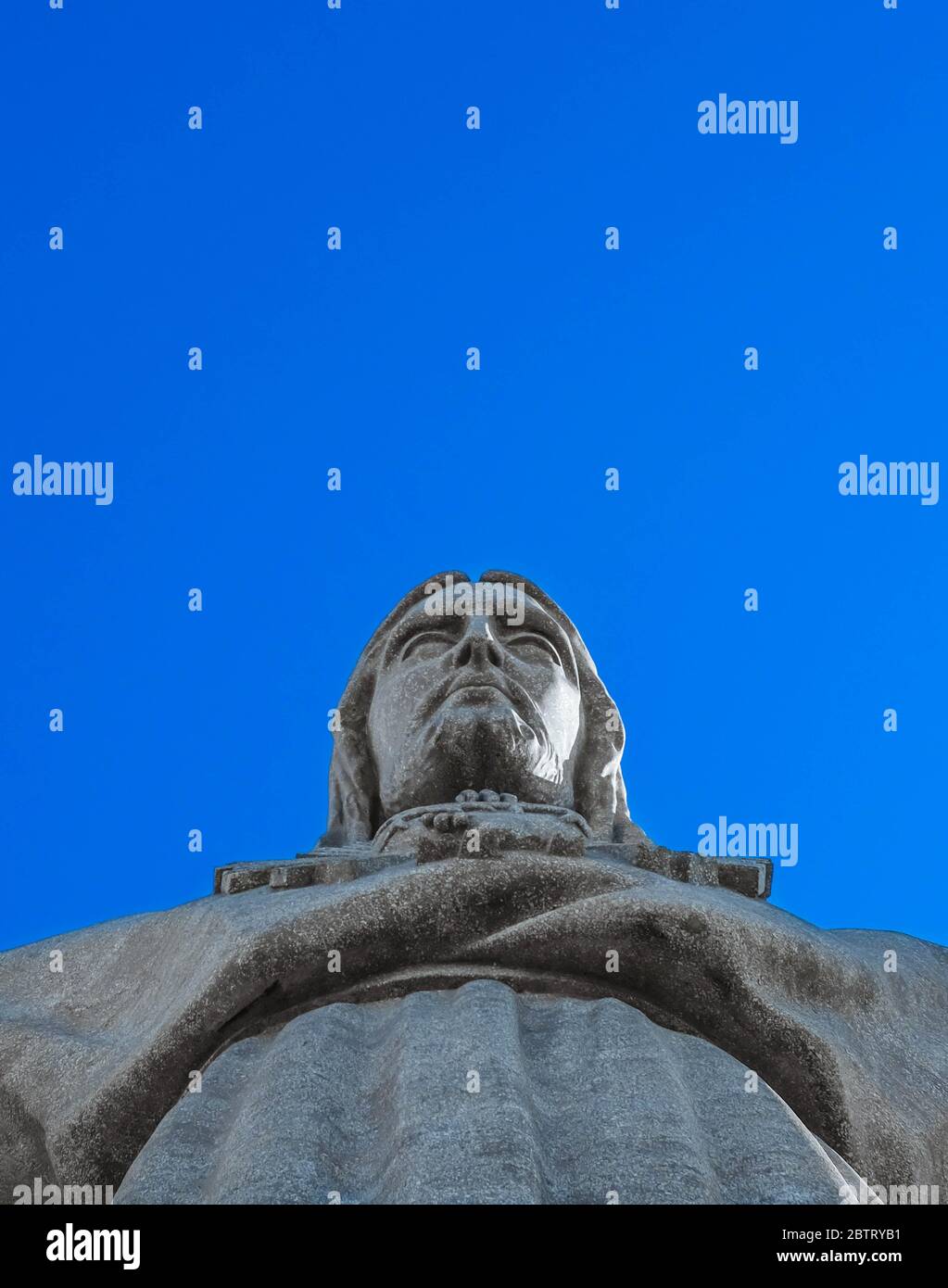 Cara de la escultura de Jesucristo con el cielo azul claro sobre un fondo. Foto de stock