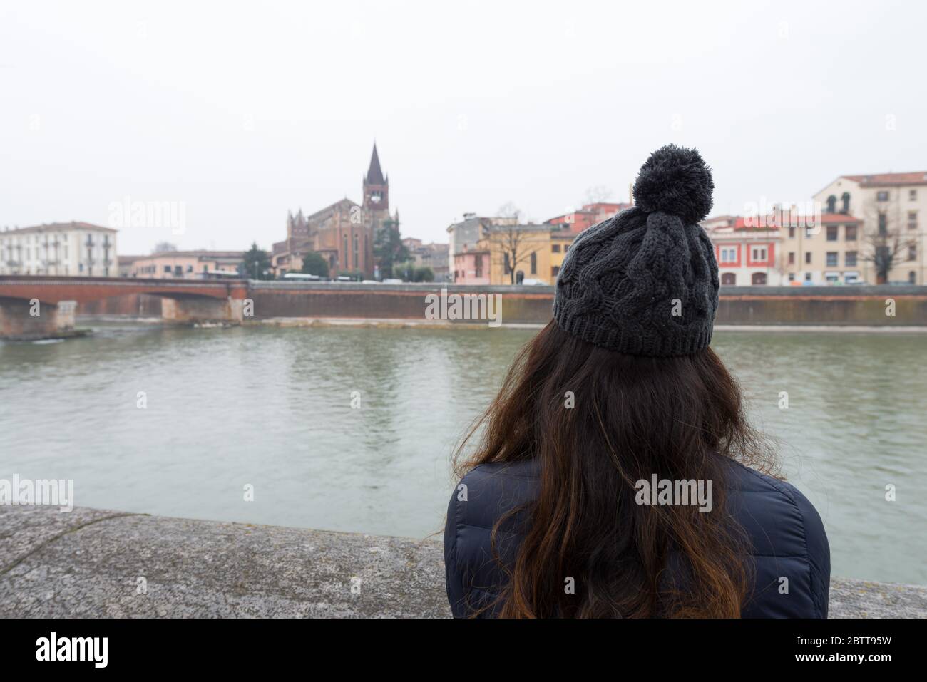 Imagen horizontal de una morena mirando al río Adige durante un día frío en Verona, Italia Foto de stock