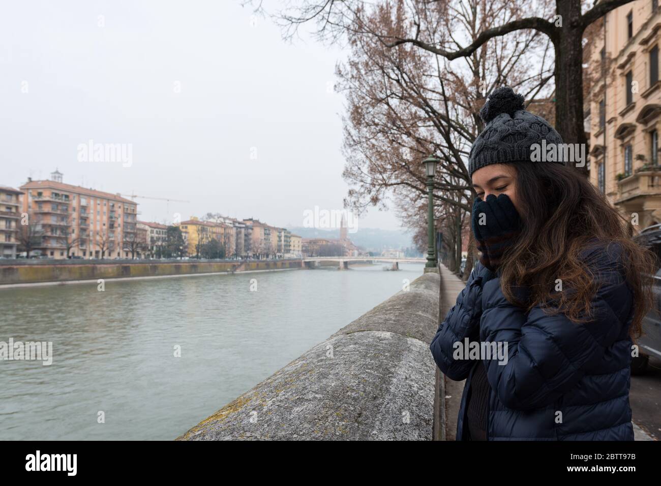 Imagen horizontal de una morena que se siente fría en Verona, Italia Foto de stock