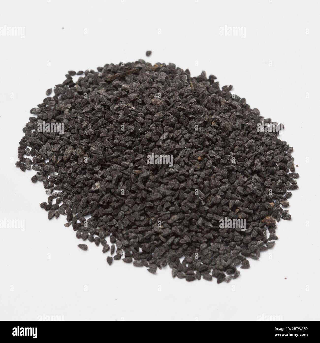 Vista de cerca del comino negro crudo sobre fondo blanco. Foto de stock