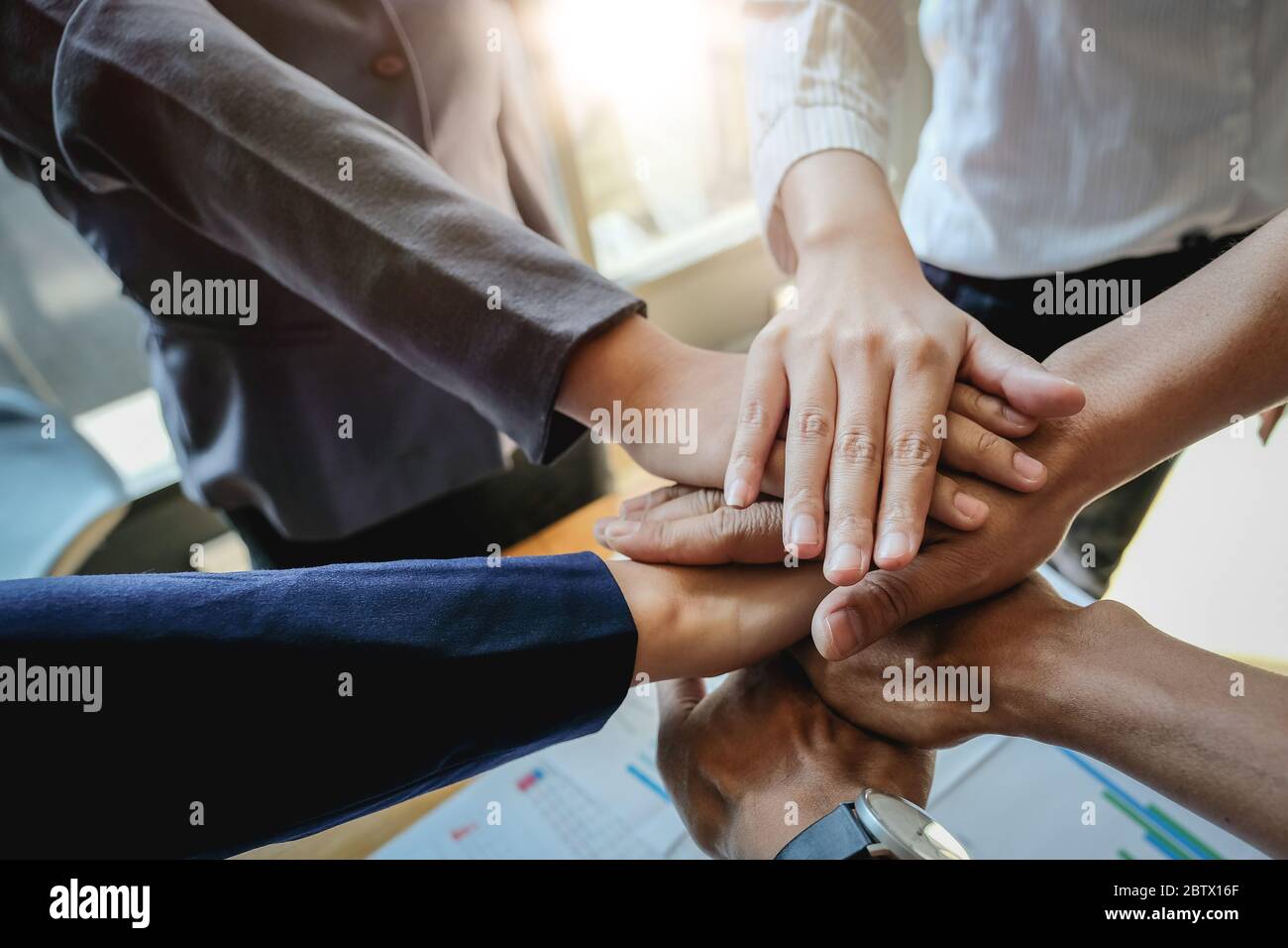 Éxito en el trabajo en equipo. Grupo de personas de negocios feliz mostrando trabajo en equipo y uniéndose a manos después de reunirse con el negocio de socios Foto de stock