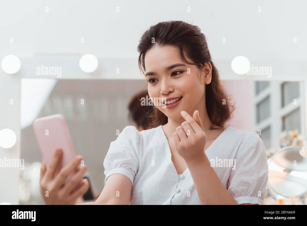 Hermosa chica con largo pelo negro tomando selfies frente al espejo  Fotografía de stock - Alamy