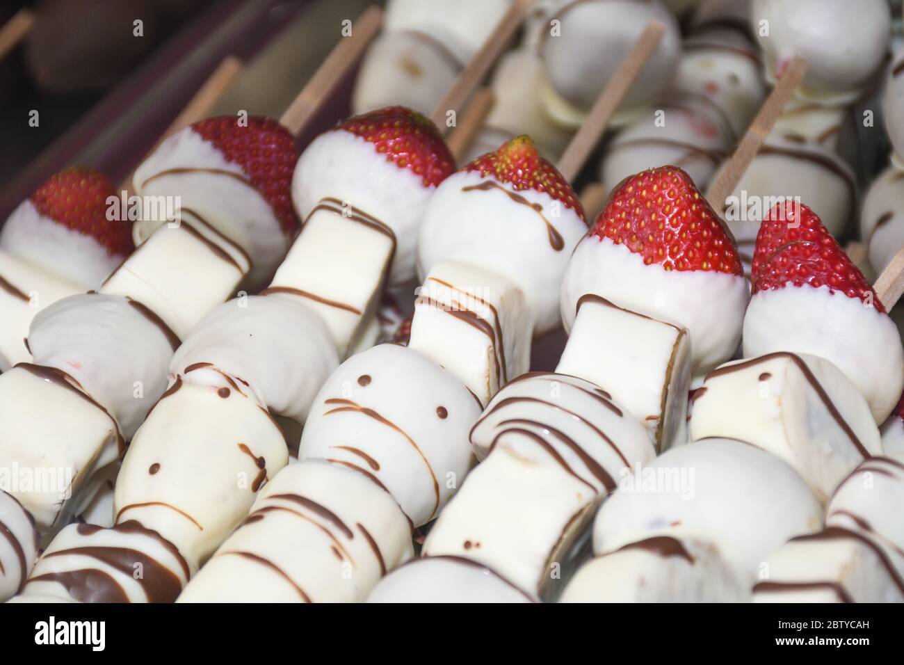 Caramelo bañado a mano manzanas cubiertas y plátanos decorados con  coloridas salpicaduras, nueces, chocolate durante la feria de Navidad del  mercado festival para la venta. Valén Fotografía de stock - Alamy