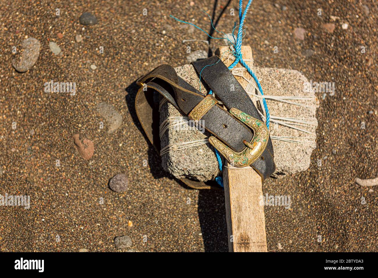 Martillo indígena hecho a mano con piedra y cinturón Foto de stock