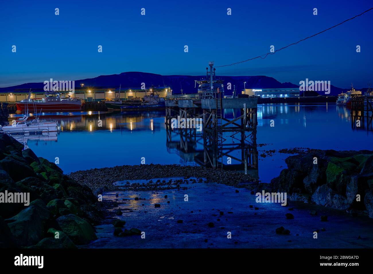 A principios de verano vista nocturna sobre el puerto de Reykjavik, barcos, luces en la luz azul de medianoche Foto de stock