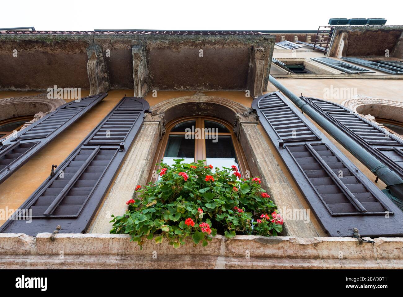 Imagen horizontal de una hermosa ventana con flores en Verona, Italia Foto de stock
