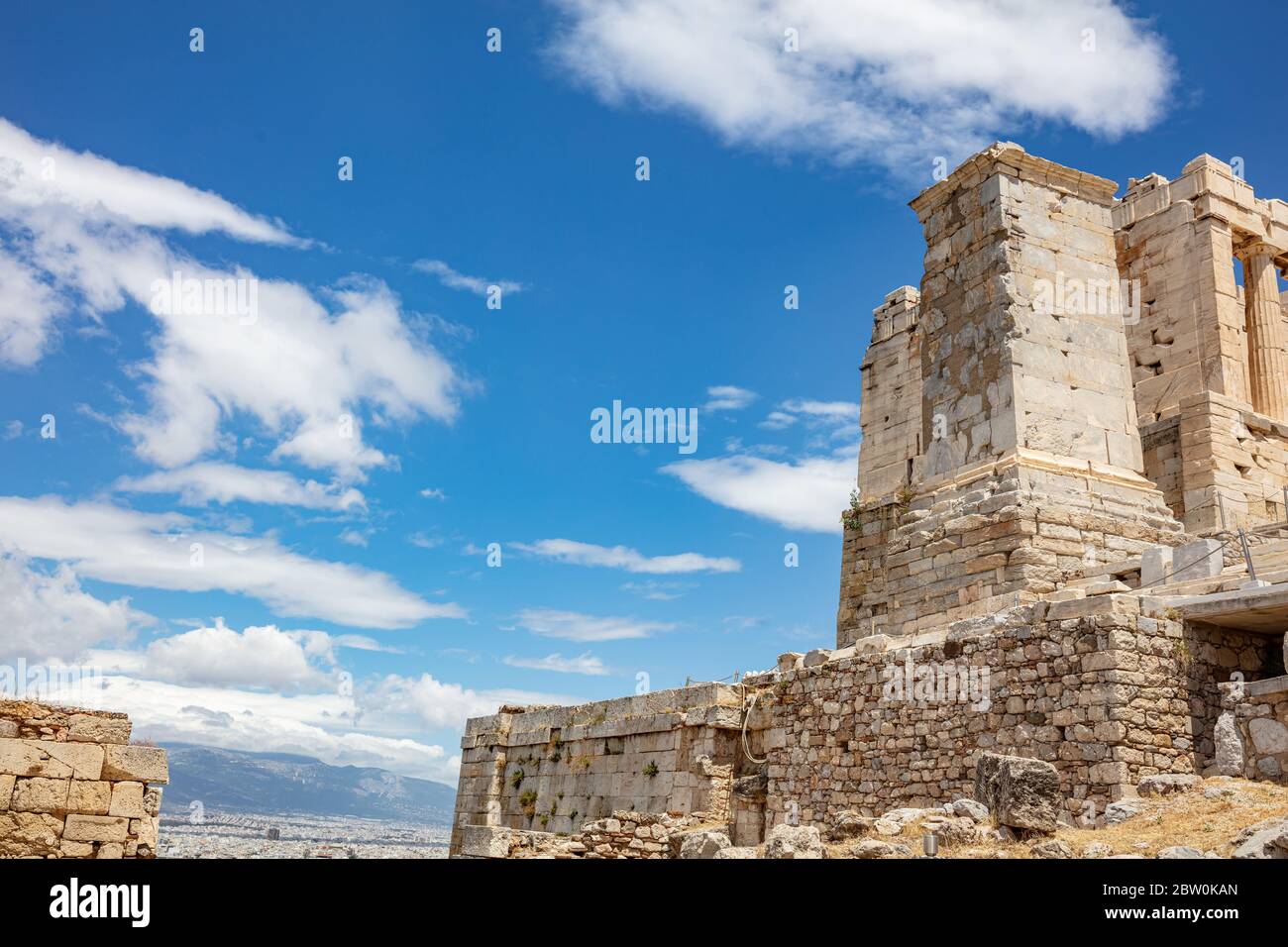 Acrópolis de Atenas, punto de referencia de Grecia. Antigua estructura griega en la puerta de entrada de Propylaea, cielo azul nublado en un día soleado de primavera. Foto de stock