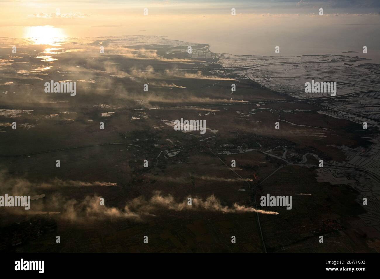 Vista aérea del paisaje costero que muestra campos agrícolas, fumaras, canales, granjas de camarones marinos y cacerolas de sal en la costa norte de la provincia de Banten, Indonesia. Foto de archivo; en vuelo. Foto de stock