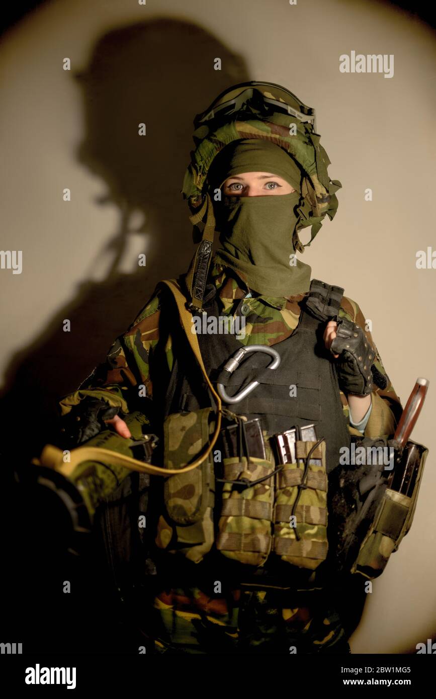 Mujer con militar con máscara sobre fondo y con vignetting. Mujer soldado en camuflaje Mujer en concepto de guerra. Retrato de mujer Fotografía de stock