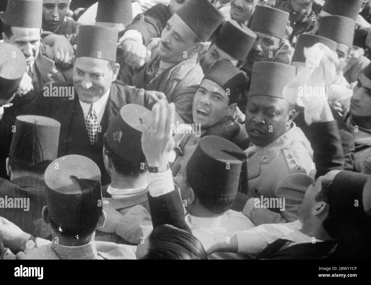 Una gran bienvenida para el primer Ministro egipcio. Cuando llega a casa de la Liga. Una multitud rápida, estimada en 200,000, llenó las calles de Alejandría para dar al primer Ministro egipcio, Nahas Pasha, una bienvenida entusiasta a su regreso de Ginebra, donde había encabezado la primera delegación egipcia a la Liga de Naciones tras la admisión de Egipto como miembro. Muestra de fotos, Nahas Pasha, el primer ministro egipcio (izquierda) rodeado de seguidores alegres a su llegada a Alejandría. 7 de junio de 1937 Foto de stock