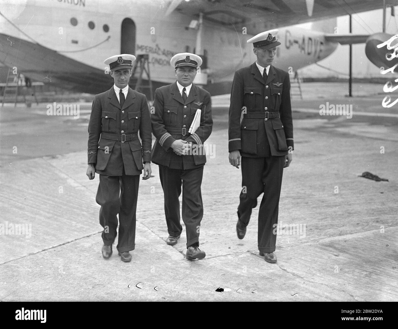 De izquierda a derecha, el capitán G.J Fowell; el Sr. B.A Moods, operador de radio; y el primer oficial C.F Elder, miembros del barco volador, están haciendo preparativos en Southampton para el segundo vuelo experimental al Atlántico que la Cambria realizará el 29 de julio. 23 de julio de 1937 Foto de stock