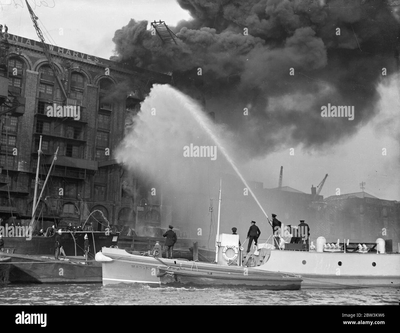 Los flotadores de fuego luchan contra el gran almacén de té que se incendia amenazando a los jardines de Londres. La lucha contra las llamas del fuego flota en el Támesis. 25 de septiembre de 1935 Foto de stock