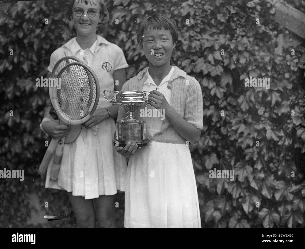 Gem Hoahing gana el título junior. Gem Hoaing, la chica China, venció a Miss R. Thomas 1 - 6 6 - 3 6 - 4 en la final de las chicas individuales del Campeonato Británico de Tenis Junior , Wimbledon . Espectáculos de fotos : Gem Hoaing con la copa después de su victoria. 12 de septiembre de 1936 Foto de stock